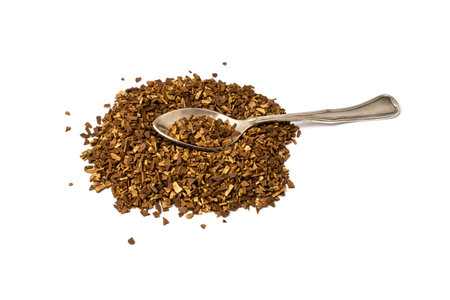 Heap of scattered instant sublimated coffee with silver spoon isolated on white background.の写真素材