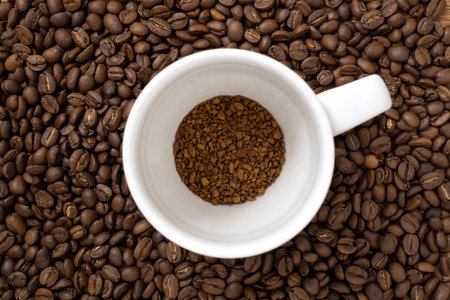 Cup with a portion of instant coffee on coffee beans background. Concept of natural coffee in granules.の写真素材