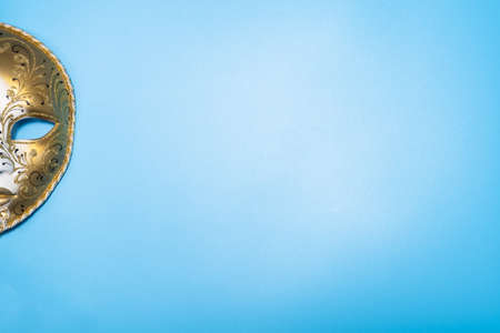 Half of Venetian masquerade mask on blue background. Copy space.の写真素材