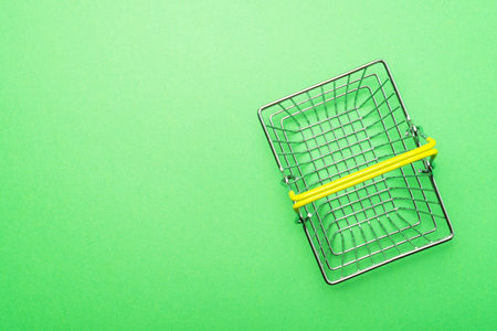 Empty shopping basket on green background, top view. Shopping concept.の写真素材