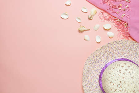 Female straw hat and seashells on light pink background. Summer holidays concept.の写真素材