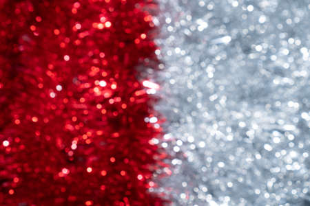 Blurred red and silver shining tinsel backdrop. New Year and Christmas defocused abstract...