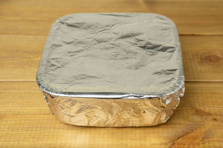 Tray with food wrapped in aluminum foil for cooking in the oven.の写真素材