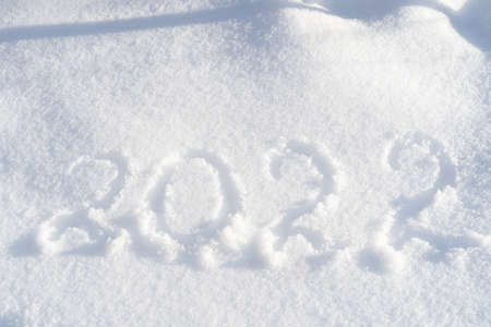 Happy new year 2022 text written on real pure white snow. New year and Christmas background.の写真素材