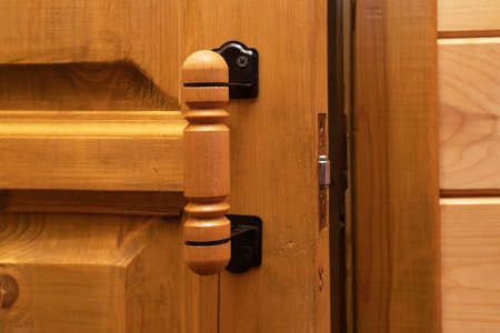 Wooden old ajar door with handle.