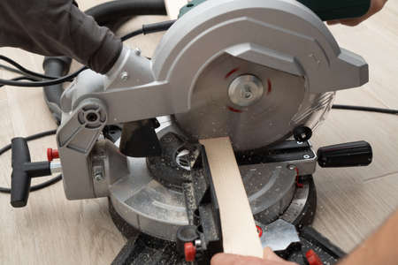 Miter saw in the process of sawing off a wooden part.の写真素材