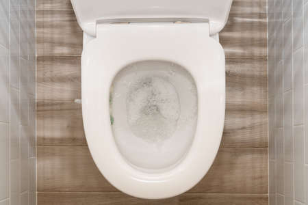Water flushing in toilet bowl, top view.の写真素材