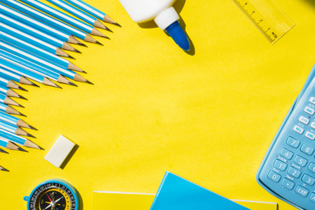 School and office supplies placed on yellow background with empty space for text. Back to school...