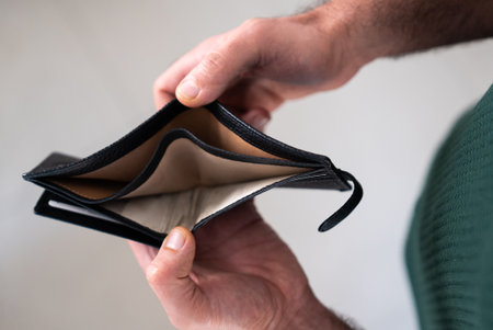 Male hands holding an open empty wallet. Concept of financial problems, economic crisis, or debt....