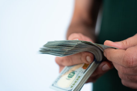 Close-up of hands holding dollar banknotes, concept of financial security, investment, and economic...