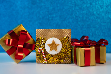 Holiday presents with golden and red ribbons on blue background. Perfect for greeting cards, Christmas and New Year designs.の写真素材