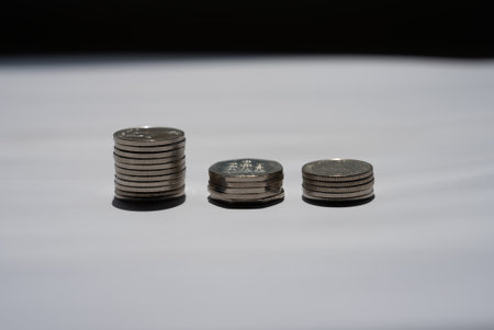 Several stacks of coins arranged in row on white background, symbol of financial savings, growth, investments, and wealth building.の写真素材