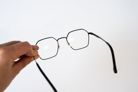 Hand showing glasses on white background. Concept of vision, optometry, healthcare, eyesight...