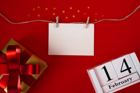 Valentines Day background with hanging blank card, gifts and calendar showing 14 February. Romantic concept.の写真素材