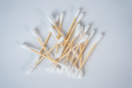 Pile of cotton swabs on white surface. Hygiene and beauty care concept, minimal clean composition for medical or cosmetic use.の写真素材
