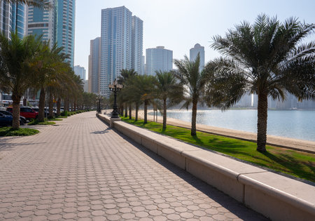 Modern seaside promenade with palm trees and skyscrapers in background. Concept of leisure, travel, and coastal living.の写真素材