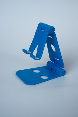 Modern blue smartphone holder photographed on white background. Simple minimalist composition, tech...