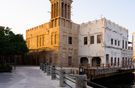 Old wind tower house in heritage area reflecting Arabian architecture and culture near water under warm evening light.の写真素材