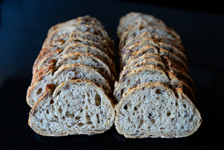 Fresh homemade bread loaves arranged on black surface. Artisan bakery and rustic food photography...