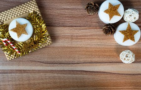 Festive holiday background with golden gift box, cookies or candles and Christmas decorations on...