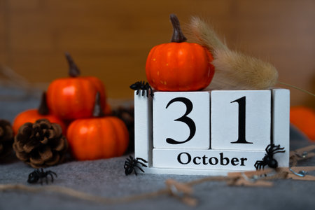 Rustic scene with 31 October calendar cubes, tiny pumpkins and natural accents on textured surface, cozy autumn holiday styling.の写真素材