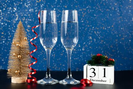 Elegant setup with champagne glasses, mini Christmas tree, and calendar showing December 31.Perfect for year-end events and festive promotions.の写真素材