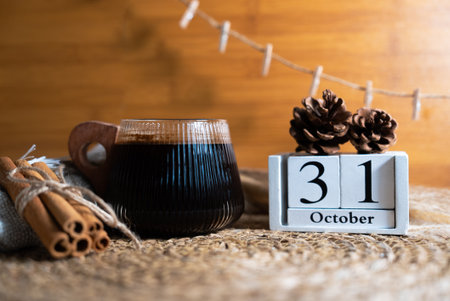 Warm autumn still life with hot coffee, rustic props, and wooden calendar block set to October 31. Perfect seasonal stock photo.の写真素材