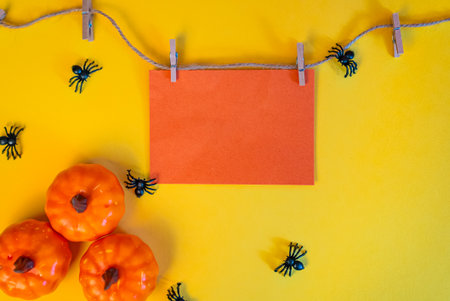 Orange card on yellow wall with pumpkins, festive autumn design for Halloween mockups, invitations and seasonal greetings.の写真素材