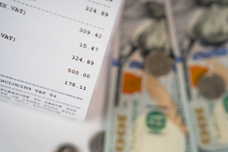 Close-up image of dollar banknotes with printed financial receipt. Concept of payment, taxes, and savingsの写真素材