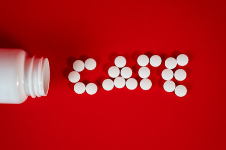 White pills arranged as word CARE on bright red surface, representing medicine, health protection, and pharmaceutical support concept.の写真素材