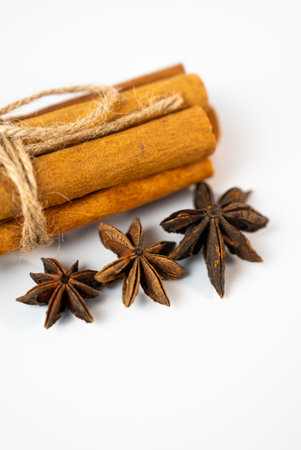 Close-up of cinnamon sticks and star anise tied with rustic rope. Ideal for recipes, winter beverages, or organic spice conceptsの写真素材