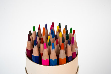 Set of sharpened color pencils arranged in a circular holder on white background, ideal for art, education, or creativity themes.の写真素材