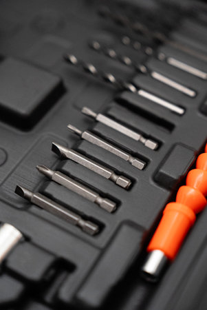 Organized tool kit with various drill bits and screwdrivers. Professional equipment for...