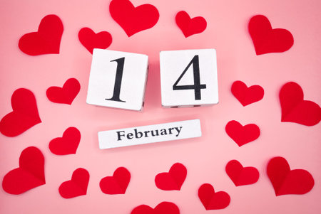 Romantic Valentine Day composition with February 14 calendar date and red hearts on soft pink background. Perfect for holiday promotions.の写真素材