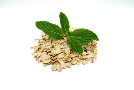 Overhead View of Rolled Oats with Green Mint Sprig on White Background. High quality photo
