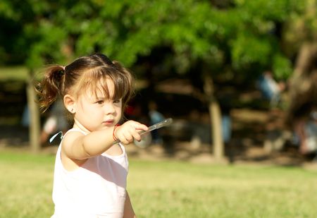 little girl stands in the park indicates somethingの写真素材