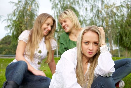 offended girl sitting on grass in the parkの写真素材