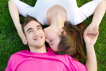 Young love couple kissing on the green grassの写真素材