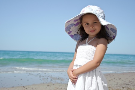 Little girl on the beach wearing funny hat.の写真素材