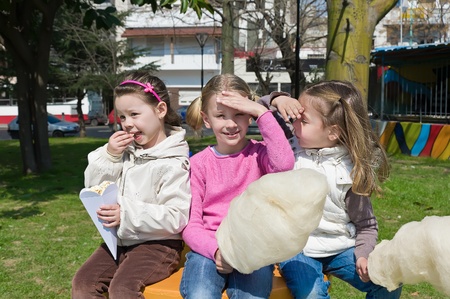 little girls eating candy-floss in the park