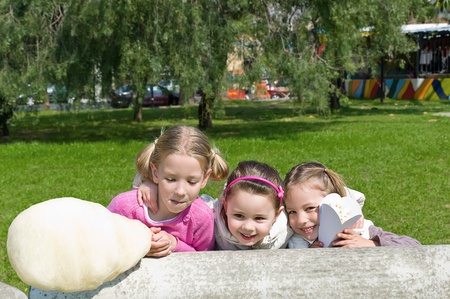 Three little sisters sitting in a parkの写真素材