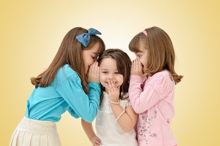 cute young sisters sharing a surprising secret