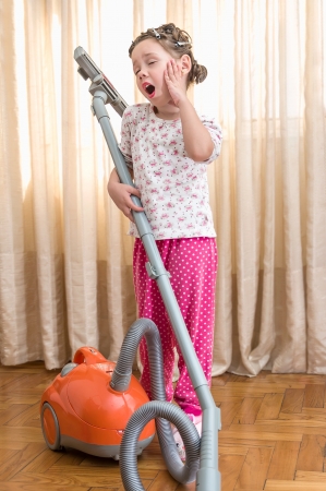 little girl with vacuum cleanerの写真素材