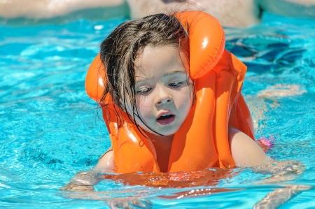 little girl swimming in a pool.