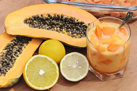 Composition of tropical fruit with a mean papaya, lime and orange juice glassの写真素材