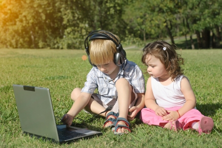 Happy childhood in nature, beautiful scene with laptop の写真素材