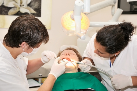 A dentist and a nurse cure patient's teethの写真素材