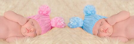 Newborn babies in pink and blue knitted hatsの写真素材