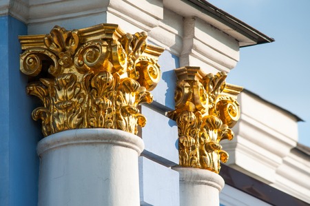 Two golden capitals on blue columns close upの写真素材