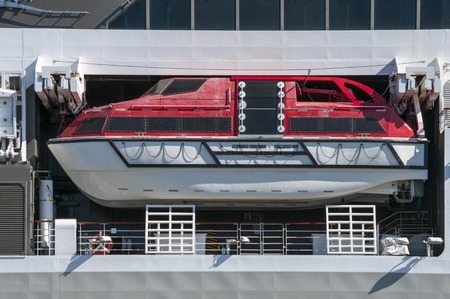 White and red life boat of a big modern cruise liner in the ocean